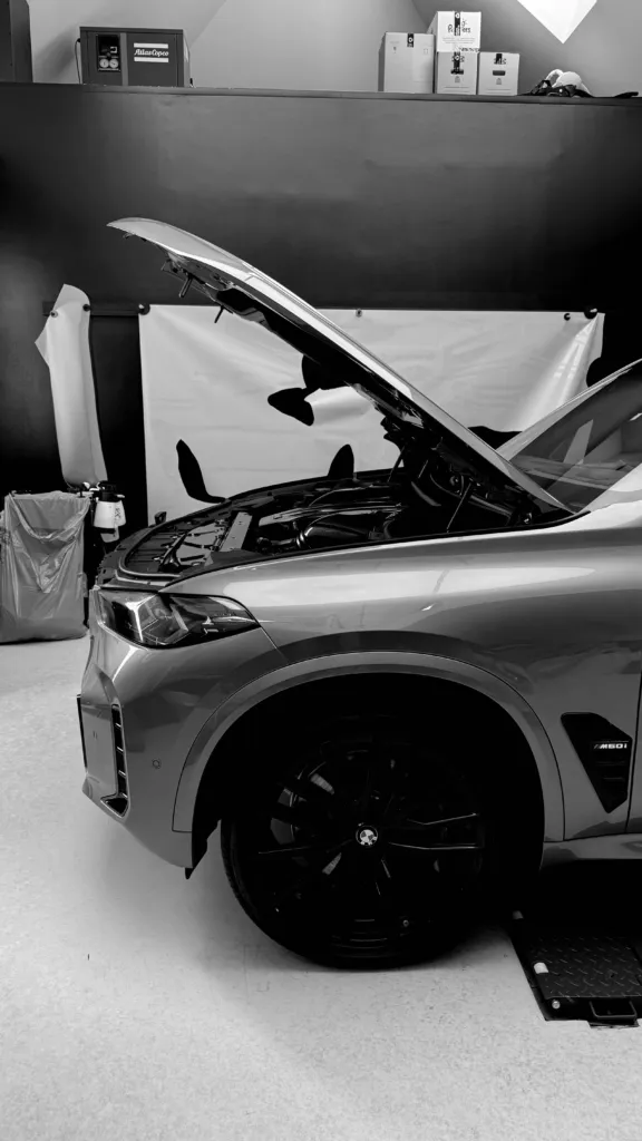 BMW X5 M60i z otwartą maską na stanowisku w studiu Virtura Customs